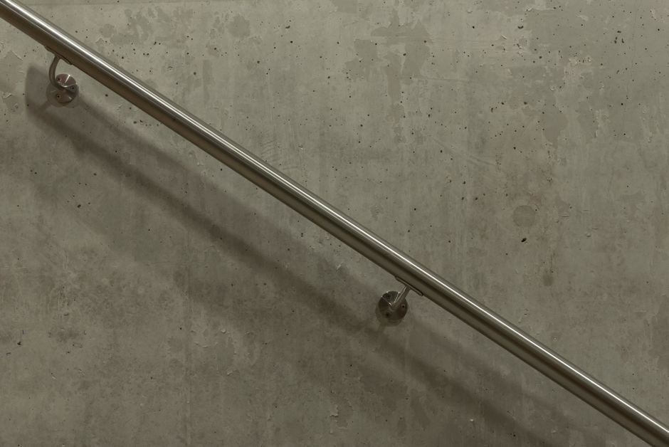Wall-mounted stainless steel grab bar in a bathroom