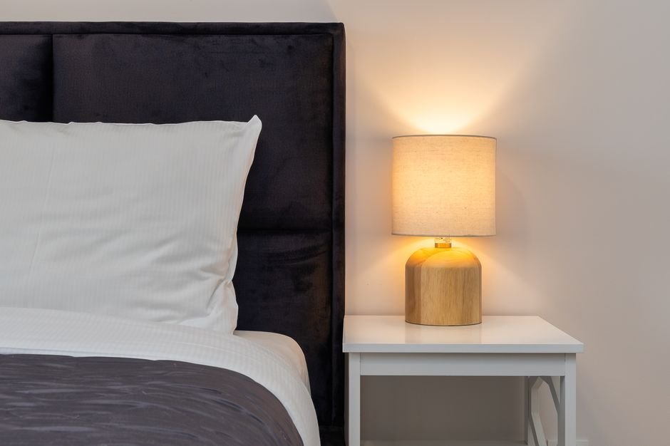 Bedside lamp on nightstand beside a bed
