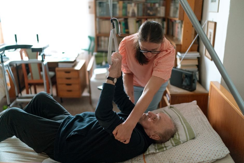 Caregiver helping an elderly man settle in at home