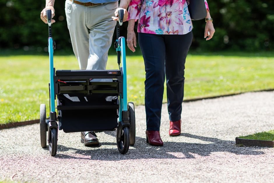 Elderly couple walking together with a walker