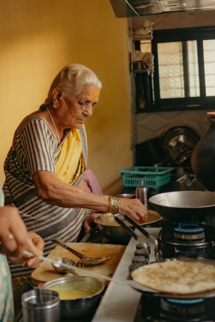 Elderly Indian woman cooking a traditional meal