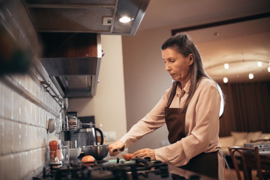 Elderly woman preparing food in a kitchen