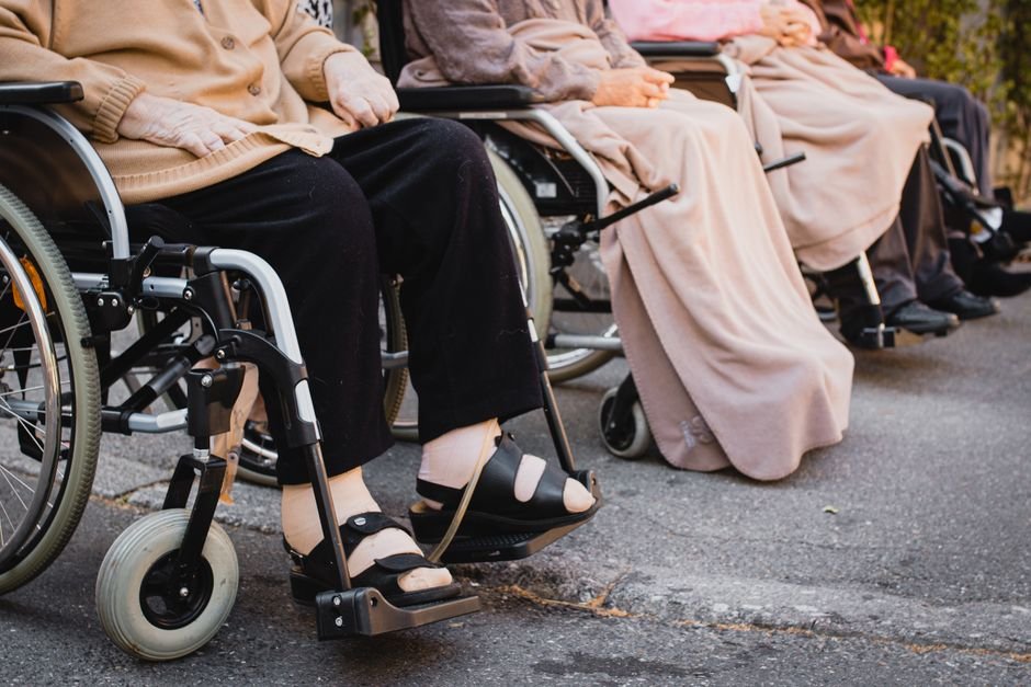 Senior adults sitting in wheelchairs outdoors