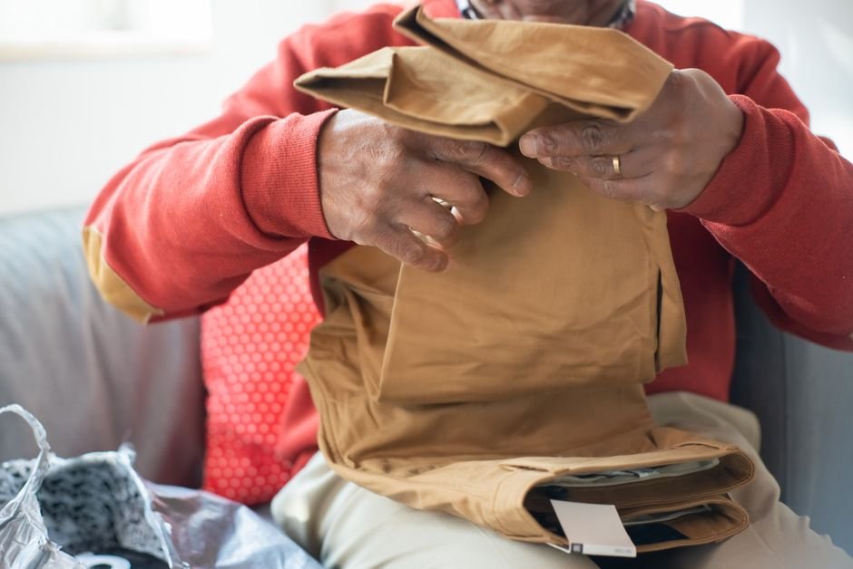 Senior adult folding clothes at home