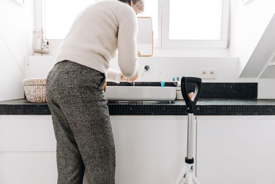 Senior adult washing hands safely in a bathroom